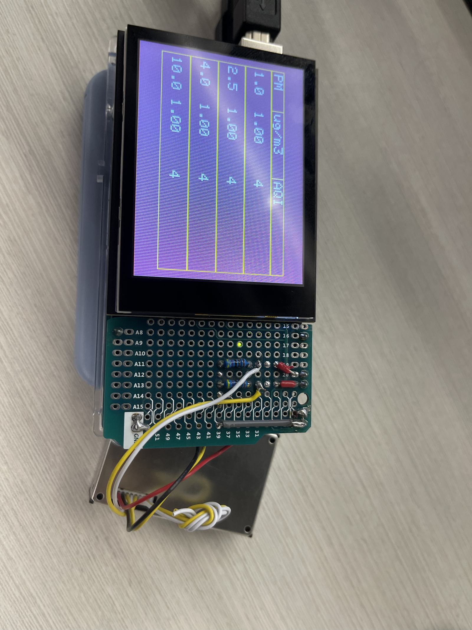 The AQI measuring prototype, reading particulate counts on its own display.